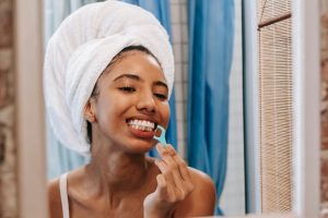 a photo of a woman flossing her teeth